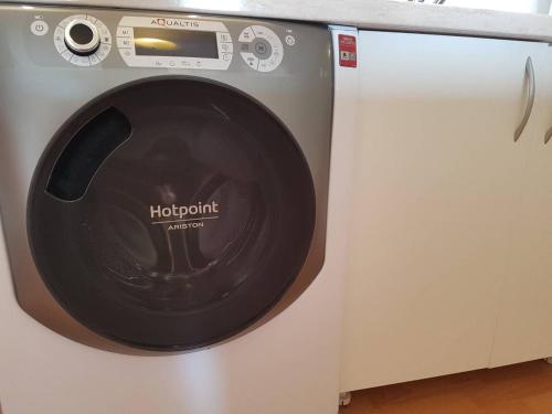 a washing machine sitting next to a white cabinet at Penthouse Modena in Novi Sad
