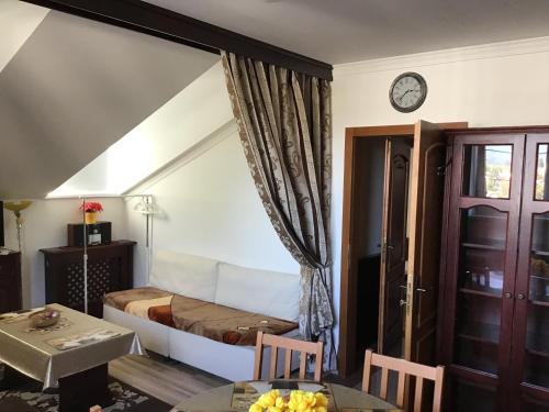 1 dormitorio con cama, mesa y reloj en Belle Vue, en Rajecké Teplice