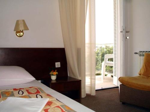 a bedroom with a bed and a door to a balcony at Hotel Adriatic in Omišalj