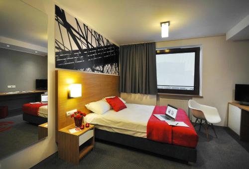 a hotel room with a bed and a desk at Link Hotel in Tczew