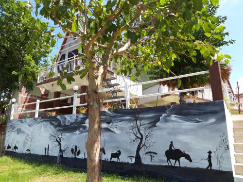 a mural on the side of a building next to a tree at Carambola Bungalow in Phong Nha