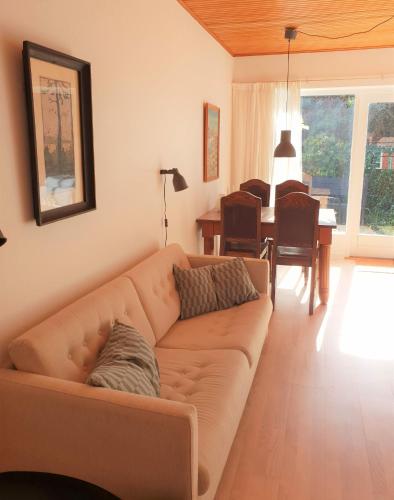 a living room with a couch and a dining room at Pension Holmegaard in Sandvig