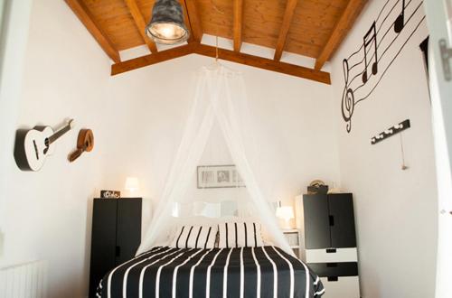 Schlafzimmer mit einem Bett mit einer schwarzen und weißen Bettdecke in der Unterkunft Casa Rural Txokoetxe in Mungia
