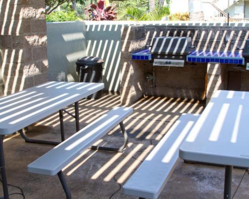 two picnic tables and a grill on a patio at Kihei Bay Surf 130- Garden View Studio, FREE PARKING in Kihei
