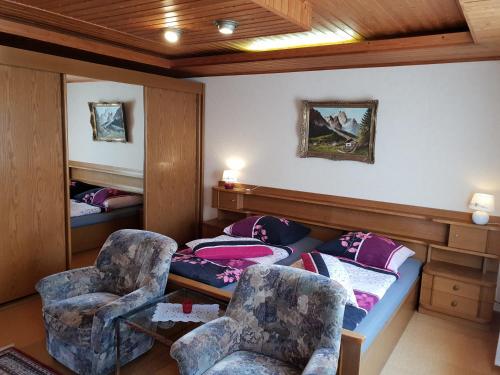 Zimmer mit einem Bett und zwei Stühlen in der Unterkunft Holiday Home Mergenhofweg in Immenhausen