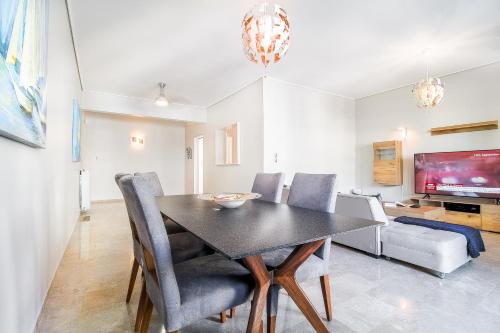 jadalnia ze stołem i krzesłami oraz telewizorem w obiekcie Luxurious 2bedroom flat near Athens center w Atenach