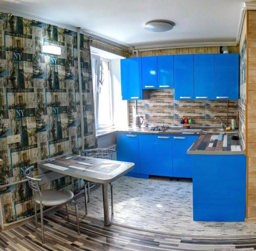a blue kitchen with a table and blue cabinets at New York 2019 in Kherson