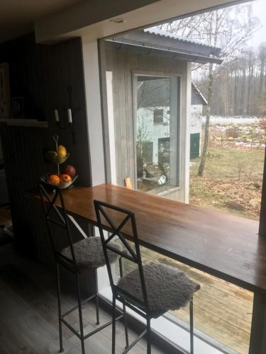 a porch with a table and two chairs and a window at The Old Henhouse in Tollarp