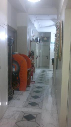 a room with a hallway with orange chairs and a floor at Hotel Stadler 2 in Rome