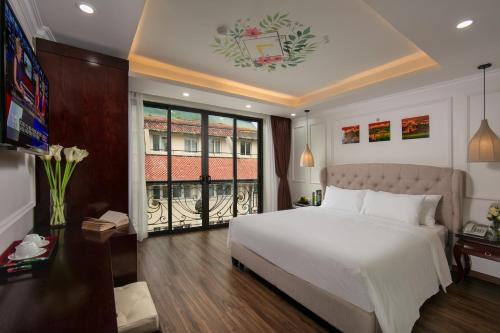 a bedroom with a large white bed and a window at Golden Legend Palace Hotel in Hanoi