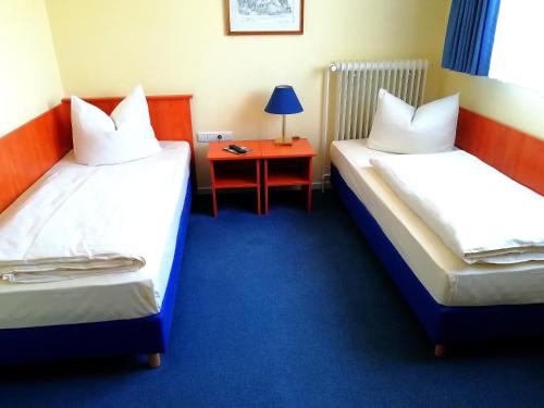 a hotel room with two beds and a table at Hotel Krohwinkel in Hittfeld