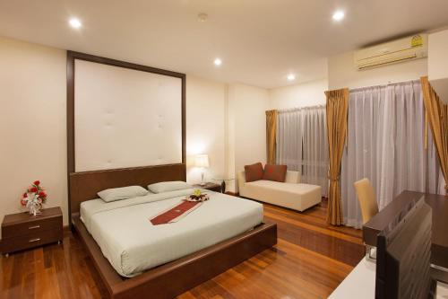 a bedroom with a bed and a living room at C-House & Residence Hotel Amata City in Pluak Daeng