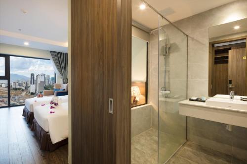 a bathroom with a bed and a shower and a sink at Xavia Hotel in Nha Trang