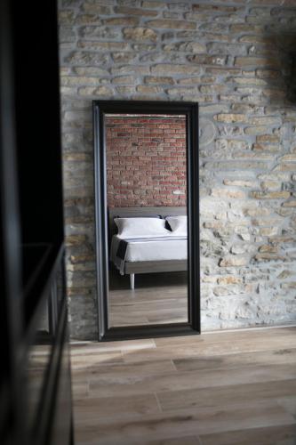 a mirror reflection of a bed in a brick wall at Country House Villa Barbero in Mango