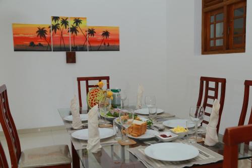a dining room table with plates and food on it at Sethum Villa Plus in Unawatuna
