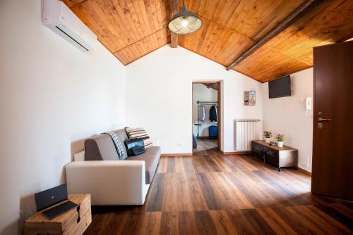 un soggiorno con divano e soffitti in legno di Domus Porto Di Traiano Resort a Fiumicino