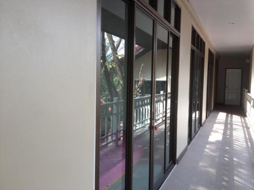 um corredor de uma casa com janelas de vidro em The Old Palace Resort Klong Sa Bua em Phra Nakhon Si Ayutthaya