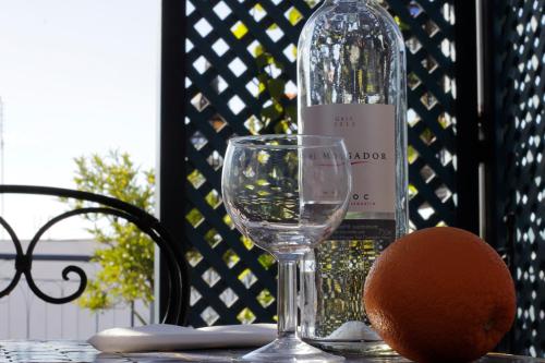 - une bouteille de vin et une orange sur une table dans l'établissement Riad Zara Maison d'Hôtes, à Marrakech
