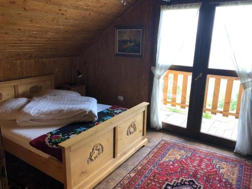 a bedroom with a bed in a room with windows at Chalet Ro in Peştera
