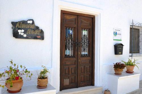 a wooden door on a white building with potted plants at Almond Reef Casa Rural in Los Alias