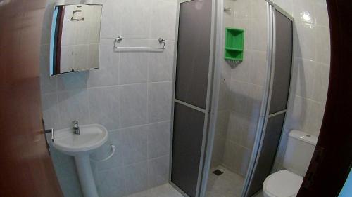 a bathroom with a shower with a toilet and a sink at Pousada Águas Formosas in Ubatuba