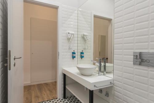 ein Bad mit einem Waschbecken und einem Spiegel in der Unterkunft Chiado Cosmopolitan Apartments in Lissabon