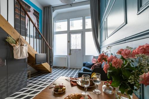 un salon avec une table et un canapé bleu dans l'établissement Artisan Lofts near Marais, à Paris