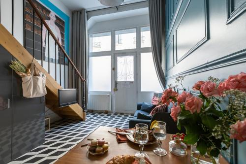 a living room with a table and a blue couch at Artisan Lofts near Marais in Paris