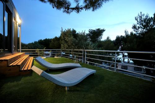 a balcony with two chairs on the grass at Mobile homes-Slanica in Murter