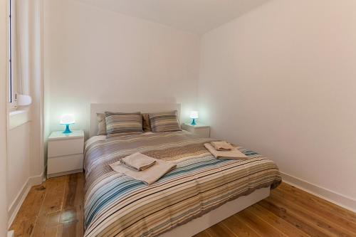 a bedroom with a large bed with two lamps on it at Apartment in Center of Lisbon in Lisbon