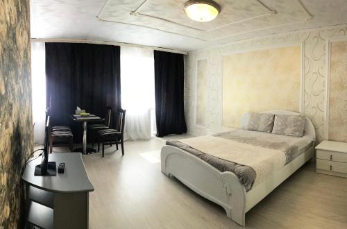 ペトロパブロフスク・カムチャツキーにあるApartment Black Sand Pogranichnayaのベッドルーム1室(ベッド1台、テーブル、椅子付)