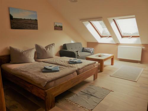 sala de estar con cama, silla y ventanas en Ferienwohnung Ortrand - Pension en Ortrand