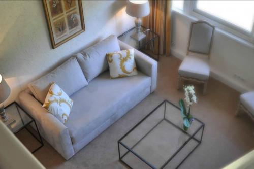 a living room with a couch and a table at Les Manoirs de Tourgéville in Deauville