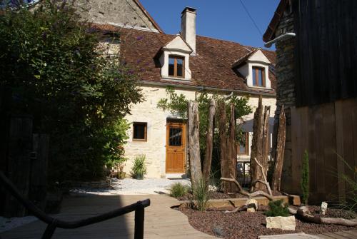 une maison avec une porte en bois dans une cour dans l'établissement Gîte des remparts, à Bèze