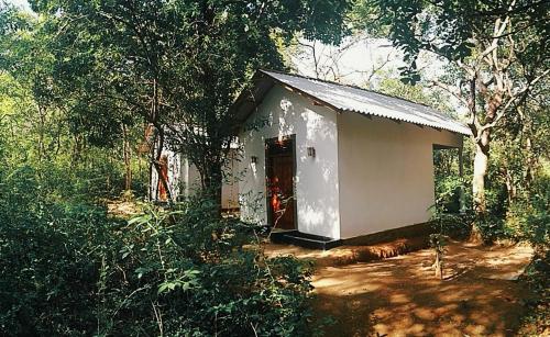 a small white building in the middle of a forest at Grand freedom in Sigiriya