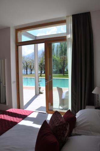 a bedroom with a bed and a sliding glass door at Tullio Hotel in Gravedona