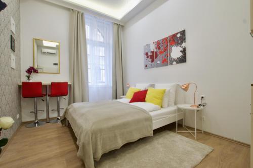 a bedroom with a white bed and red and yellow pillows at St King 11 by Hi5 Apartments in Budapest