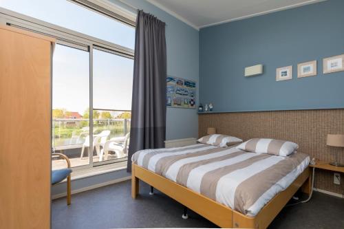 a bedroom with a bed and a large window at Nautic Rentals - Marinapark Oude-Tonge in Oude-Tonge