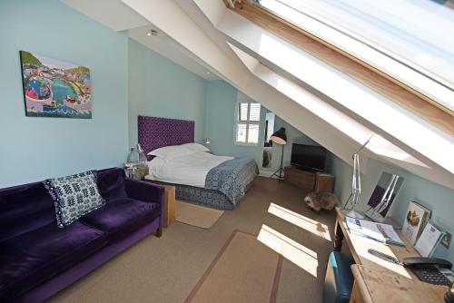 a living room with a couch and a bed and a window at Harbourmaster Hotel in Aberaeron