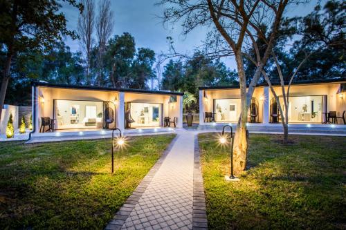 a house with lights in the yard at night at Hlangana Lodge in Oudtshoorn