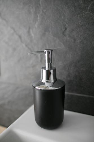 a black soap dispenser sitting on top of a sink at Country House Villa Barbero in Mango