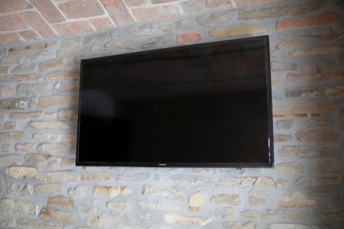 a flat screen tv mounted on a brick wall at Country House Villa Barbero in Mango