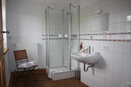 a bathroom with a shower and a sink and a glass shower stall at Landhaus Hui Wäller in Beilstein