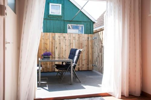 un patio con mesa y sillas y un granero en Heerlijk Huis aan het IJsselmeer en Stavoren