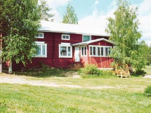 una casa roja en un campo con un árbol en Holiday Home Raanumaja ii by Interhome, en Lampsijärvi