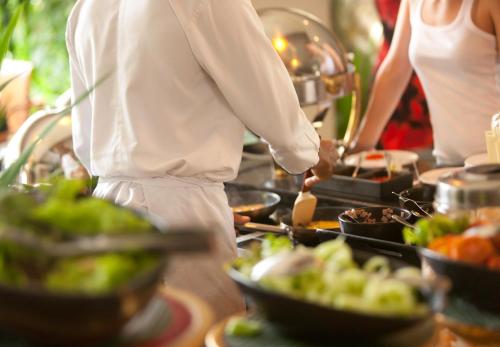 un chef que prepara comida en una mesa de buffet en Solo Sokos Hotel Turun Seurahuone, en Turku