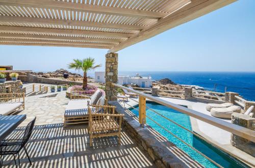 Un balcón con sillas y vistas al océano. en Eden View Suites & Villas en Paradise Beach