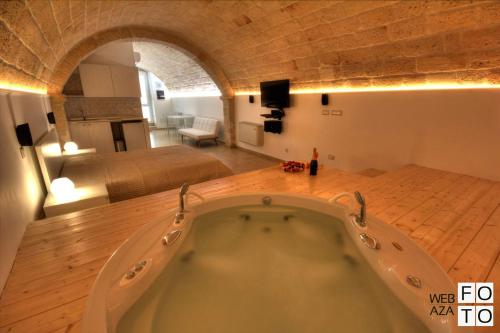 a large bath tub in a room with a bedroom at Suite Stone Luxury in Monopoli