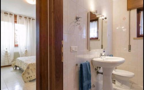 a bathroom with a sink and a toilet and a mirror at Yellow house in Vicenza