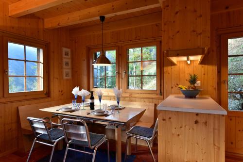 a dining room with a table and chairs and windows at Chalet Fresch in Grimentz